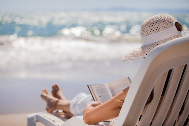 femeie citeste pe plaja vara
